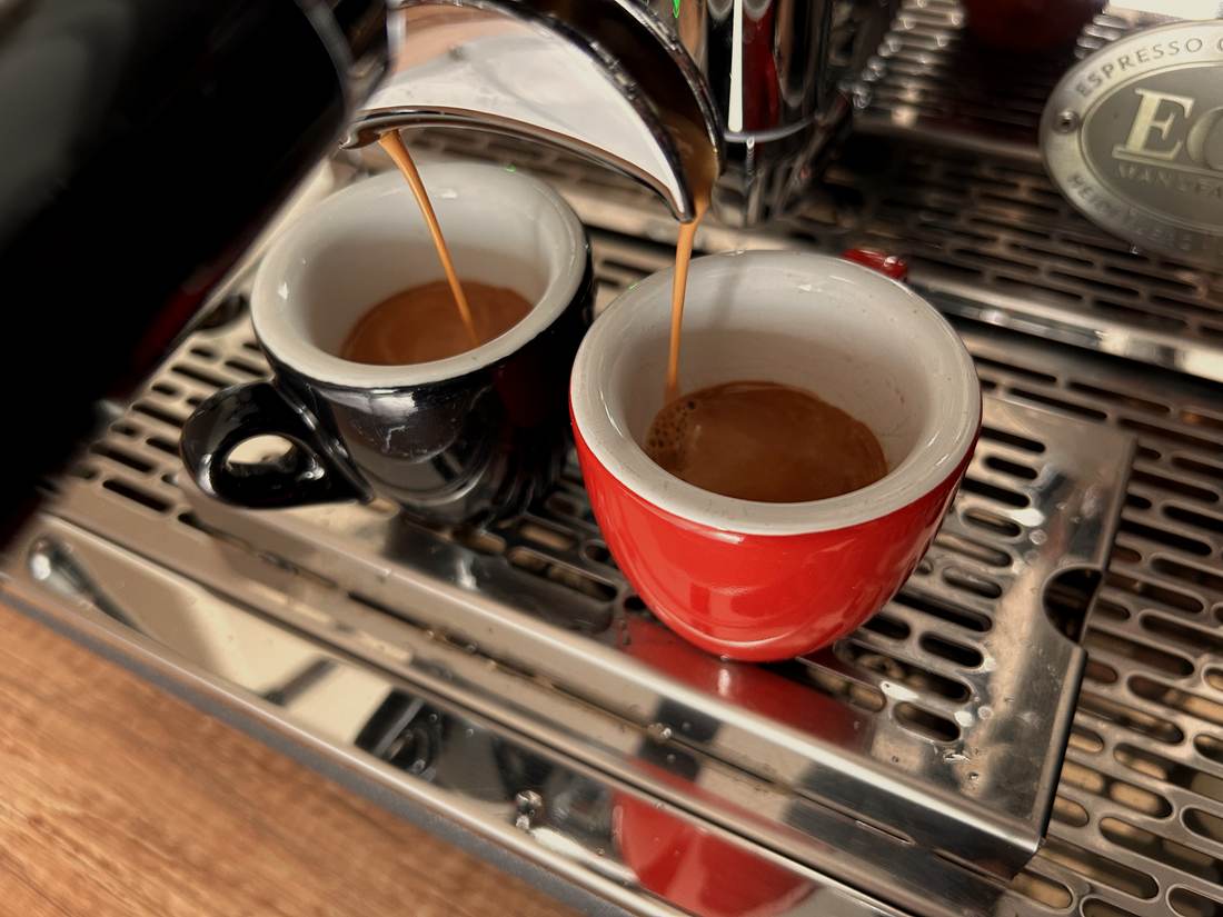 Espresso läuft aus dem Siebträger in zwei Tassen